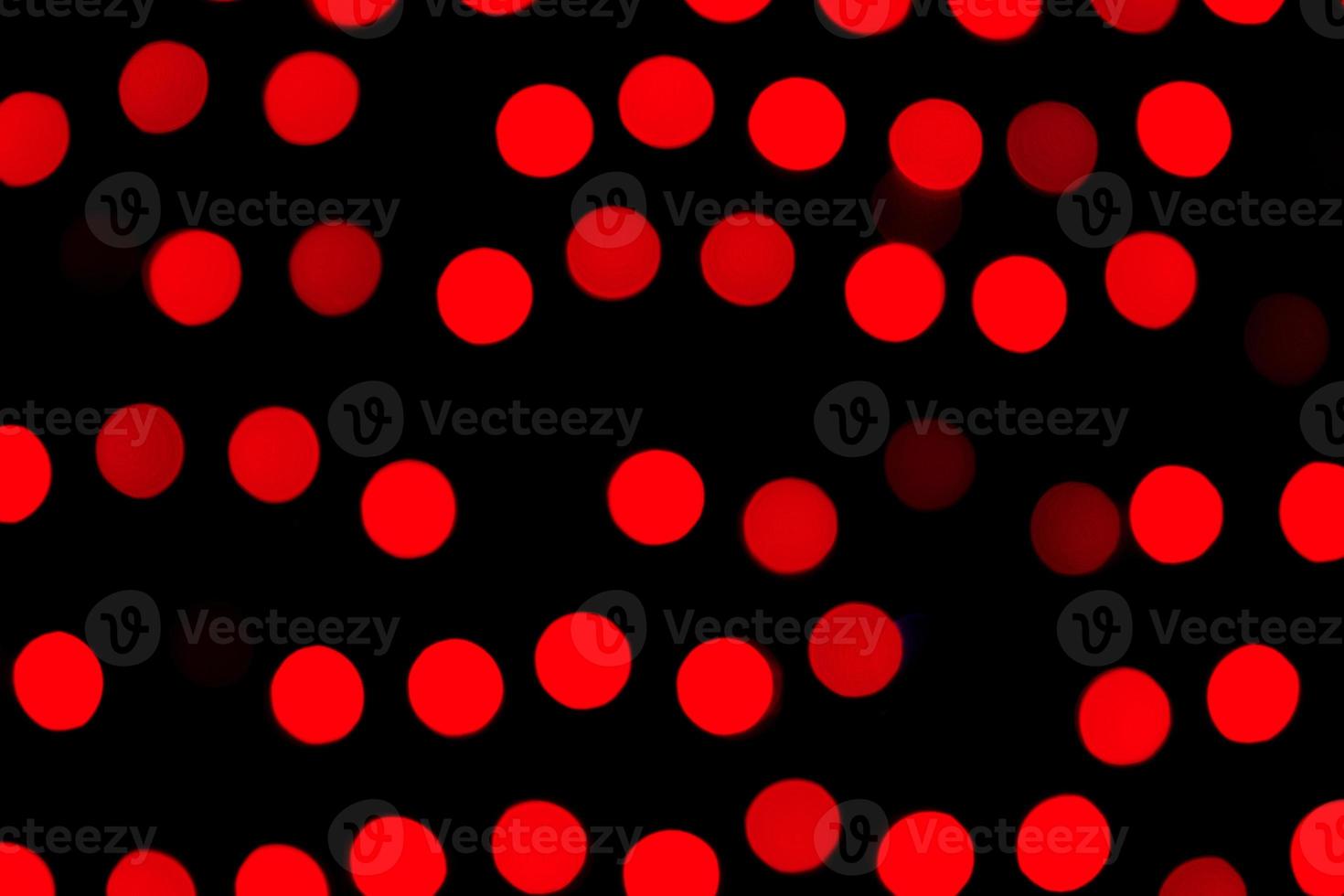 ofokuserad abstrakt röd bokeh på svart bakgrund. defocused och suddig många runda ljus foto