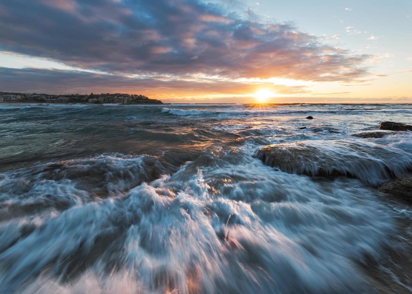 soluppgång på stranden med rusande vatten foto