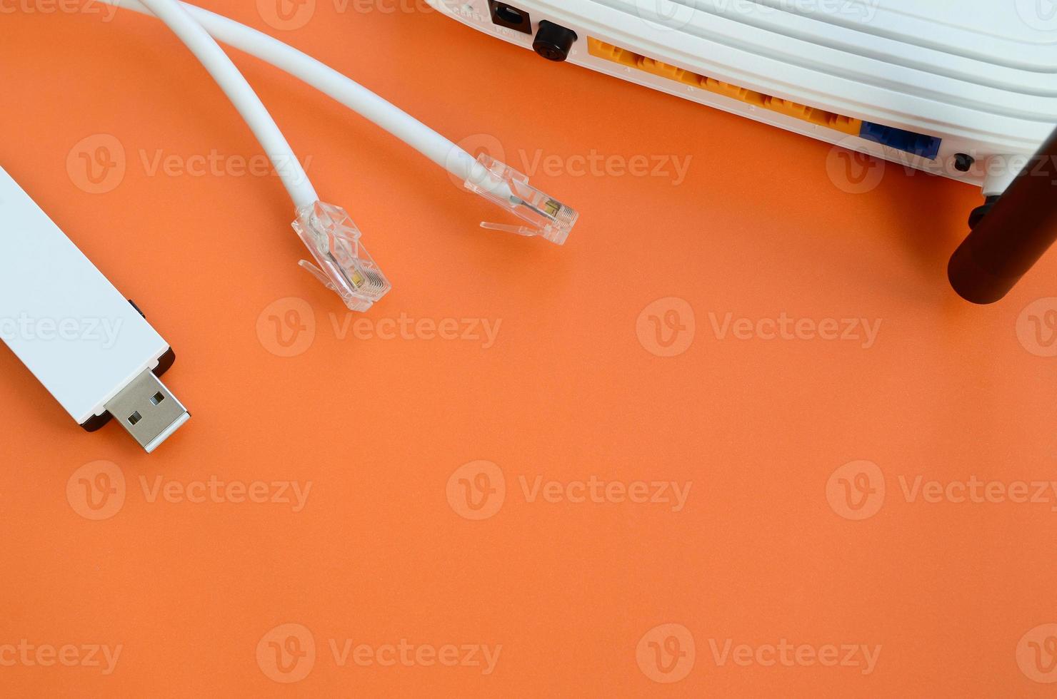 internet router, bärbar uSB Wi-Fi adapter och internet kabel- pluggar lögn på en ljus orange bakgrund. objekt nödvändig för internet förbindelse foto