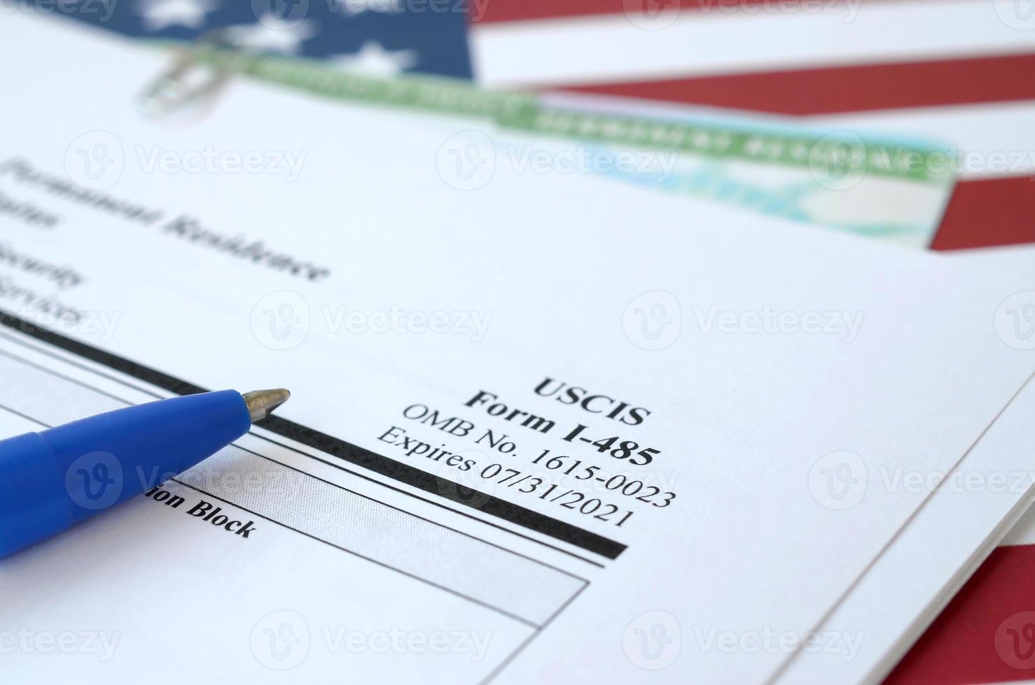 i-485 Ansökan till Registrera permanent bostad eller justera status form och grön kort från dv-lotteri lögner på förenad stater flagga med blå penna från avdelning av hemland säkerhet foto
