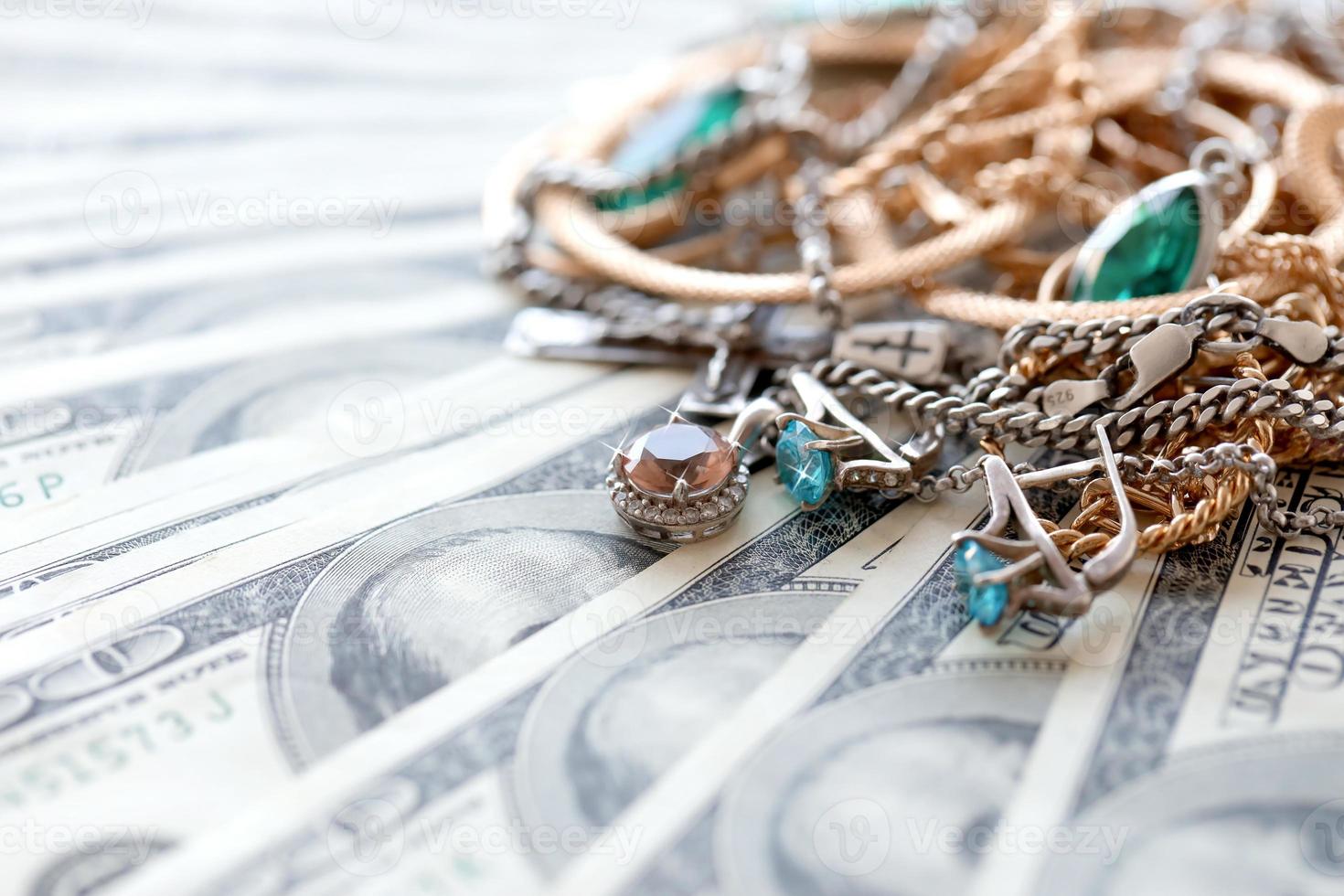 många dyr gyllene och silver- jewerly ringar, örhängen och halsband på stor belopp av oss dollar räkningar stänga upp. pantbank eller jewerly affär foto