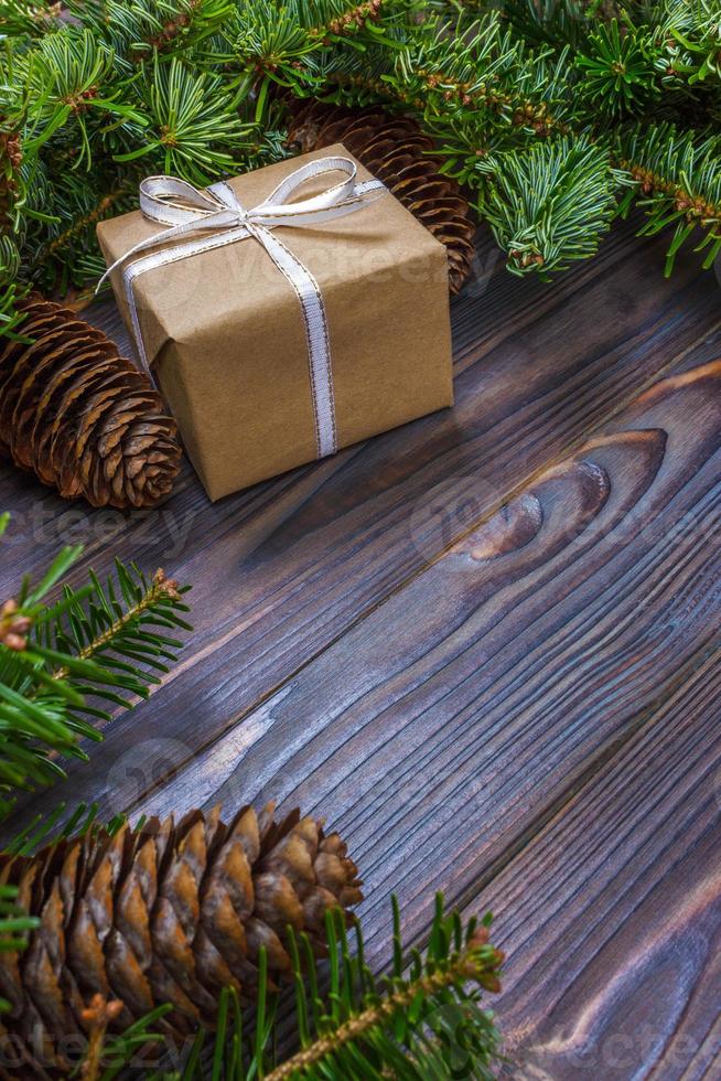 gåva låda med gran grenar på trä- bakgrund foto