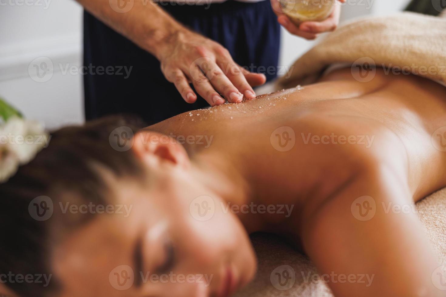 kvinna njuter peeling massage med salt i spa Centrum foto