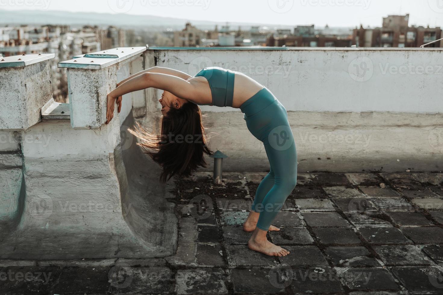 kvinna håller på med yoga utomhus på en taket terrass foto