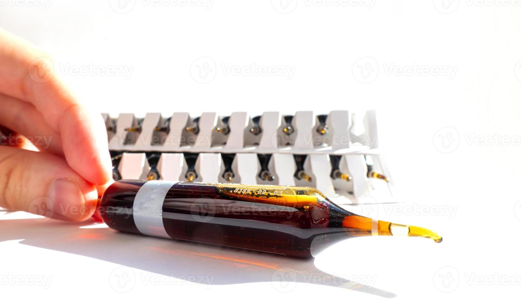 grupp av ampuller med en transparent medicin i medicinsk laboratorium. massa av ampuller på ljus bakgrund. foto