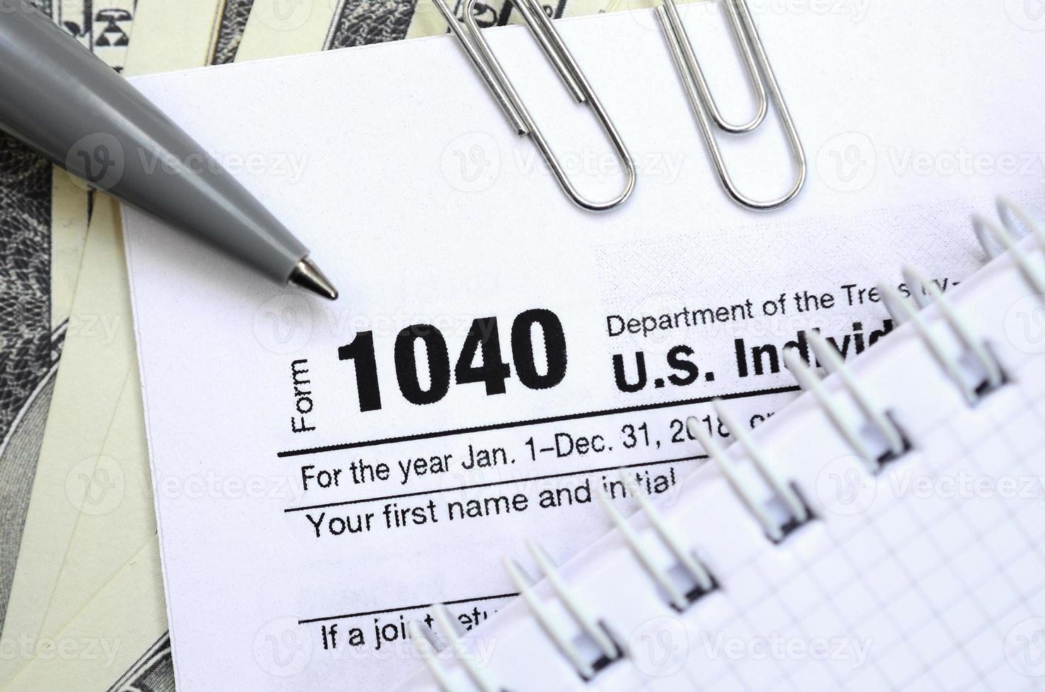 de penna, anteckningsbok och dollar räkningar är lögner på de beskatta form 1040 oss enskild inkomst beskatta lämna tillbaka. de tid till betala skatter foto