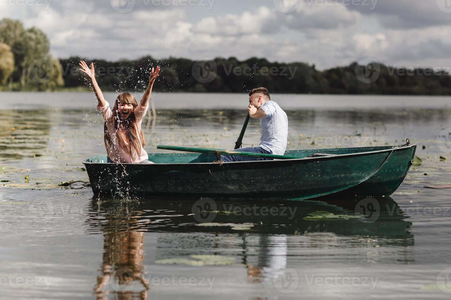 känsla lekfull. skön ung par njuter romantisk datum medan rodd en båt. Lycklig till ha varje Övrig. foto