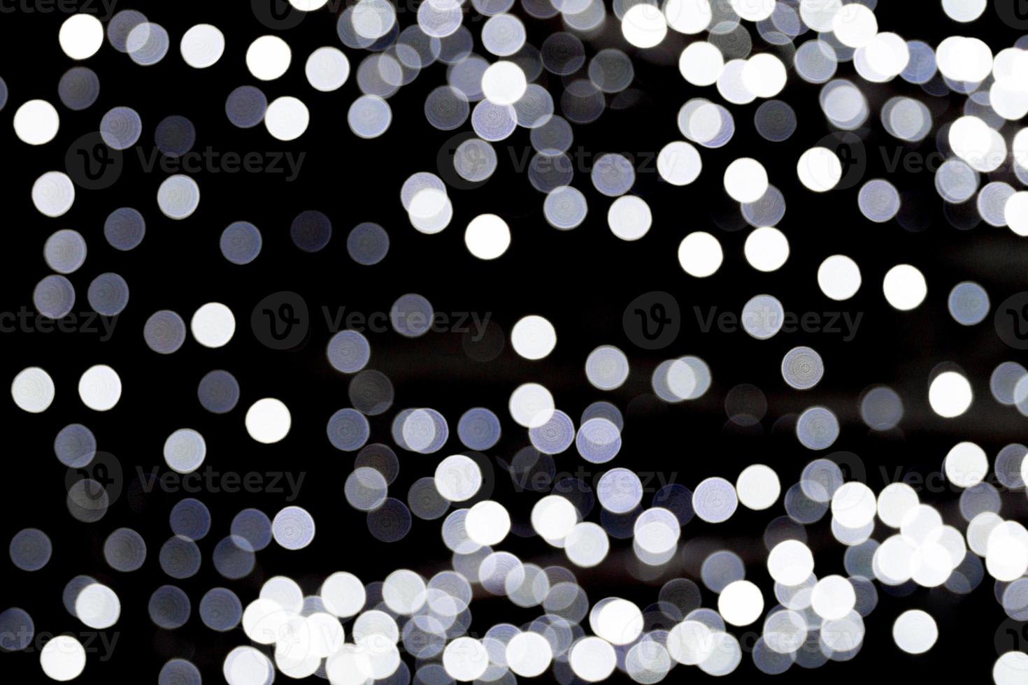 abstrakt glitter gnistra bokeh defocused på svart bakgrund. många runda ljus på bakgrund foto