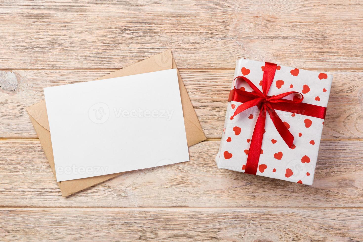 kuvert post med röd hjärta och gåva låda över orange trä- bakgrund. valentine dag kort, kärlek eller bröllop hälsning begrepp foto