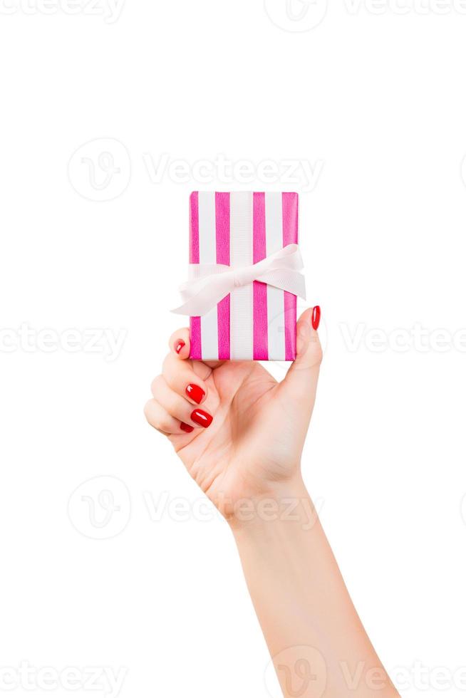 kvinna händer ge insvept jul eller Övrig Semester handgjort närvarande i rosa papper med vit band. isolerat på vit bakgrund, topp se. tacksägelse gåva låda begrepp foto
