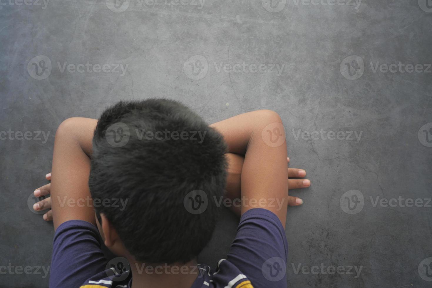 Tonårs pojke huvud ner på skrivbord foto