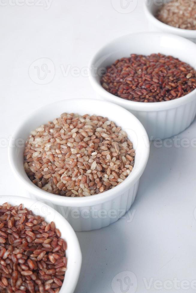 fyra olika typer av ris i en skål på vit bakgrund foto
