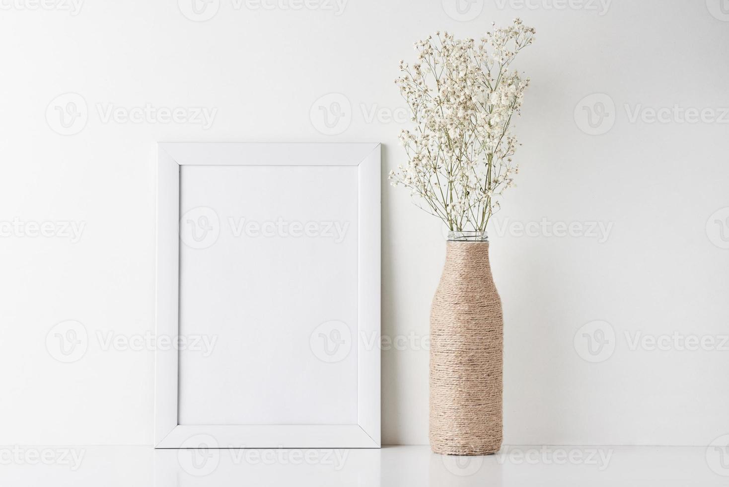 arbetsyta skrivbord med tömma ram och blomma i vas foto