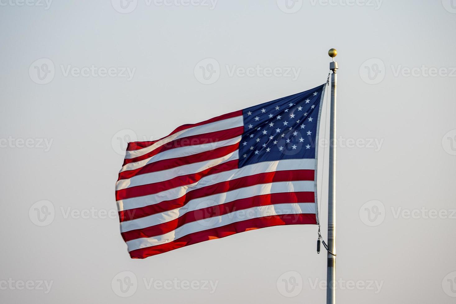 amerikan nationell flagga vinka i de luft förbi klar himmel foto