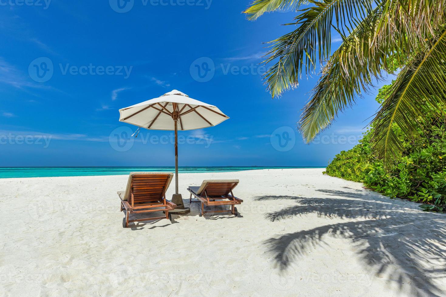 skön tropisk landskap, par stolar Sol sängar paraply under handflatan löv. sommar bakgrund, exotisk resa strand, solig dag paradis kust. Fantastisk landskap, hav sand himmel koppla av tillflykt semester foto