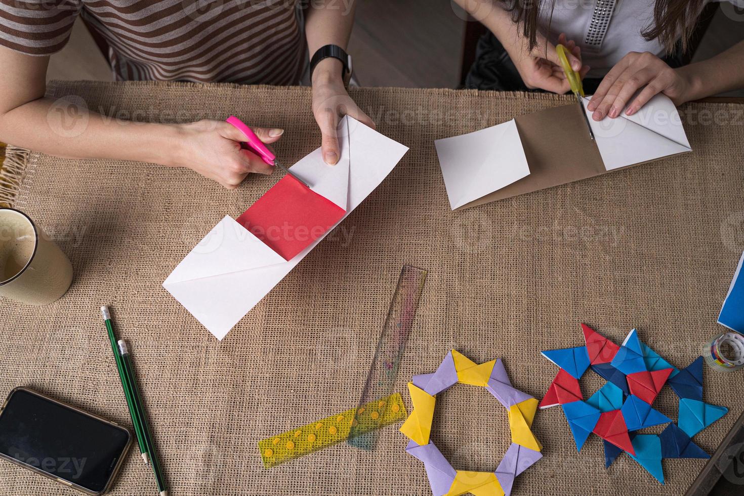mamma och dotter göra origami från färgad papper på självisolering foto