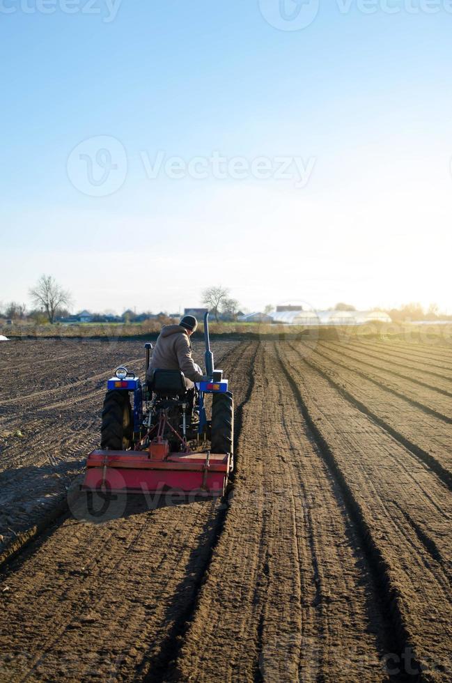 de traktor är odla de jord i de bruka fält. uppmjukning och förbättra jord kvaliteter. framställning för skärande rader för de Nästa sådd säsong i de vår. jordbruk. foto