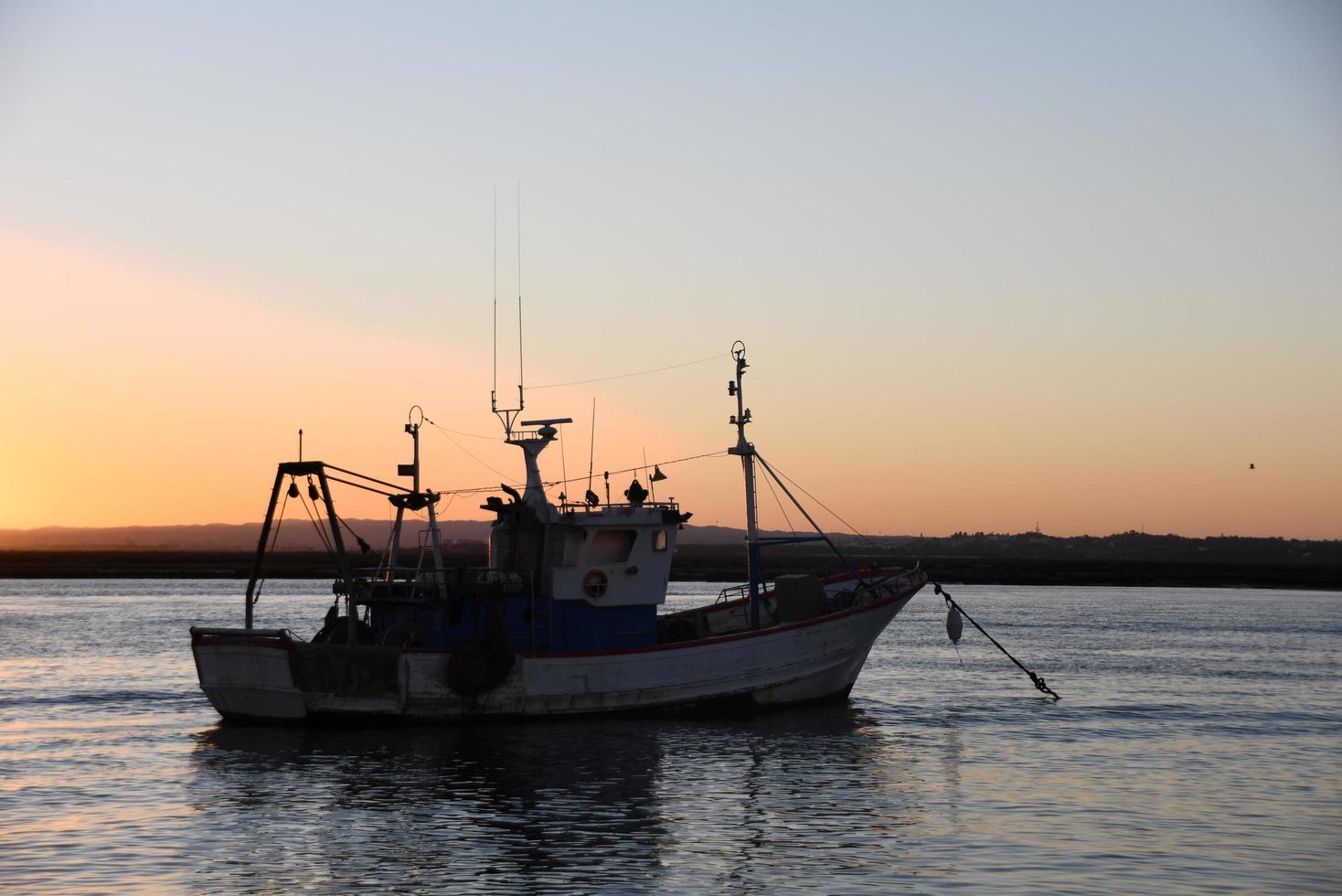 fiskebåt i havet vid solnedgången foto