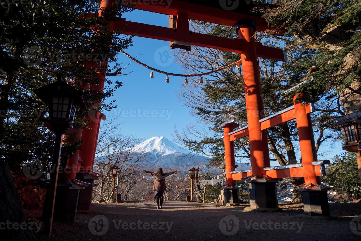 resa japan på vinter, kvinna Uppfostrad händer med en jätte toriien Port eller röd Pol och fuji berg. foto