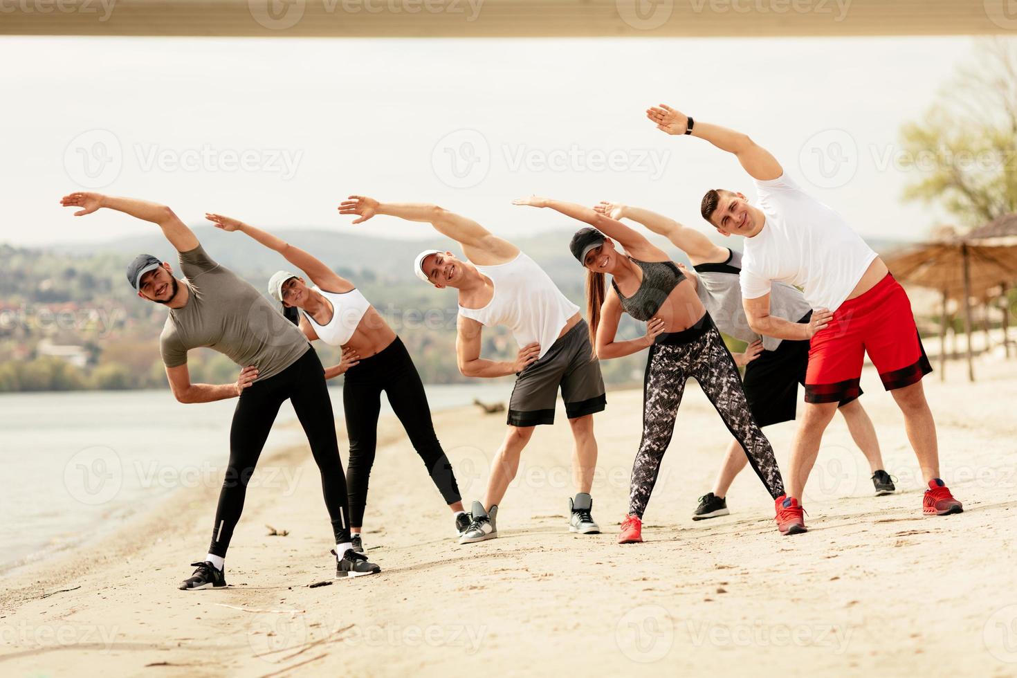 grupp vänner utövar på de strand foto