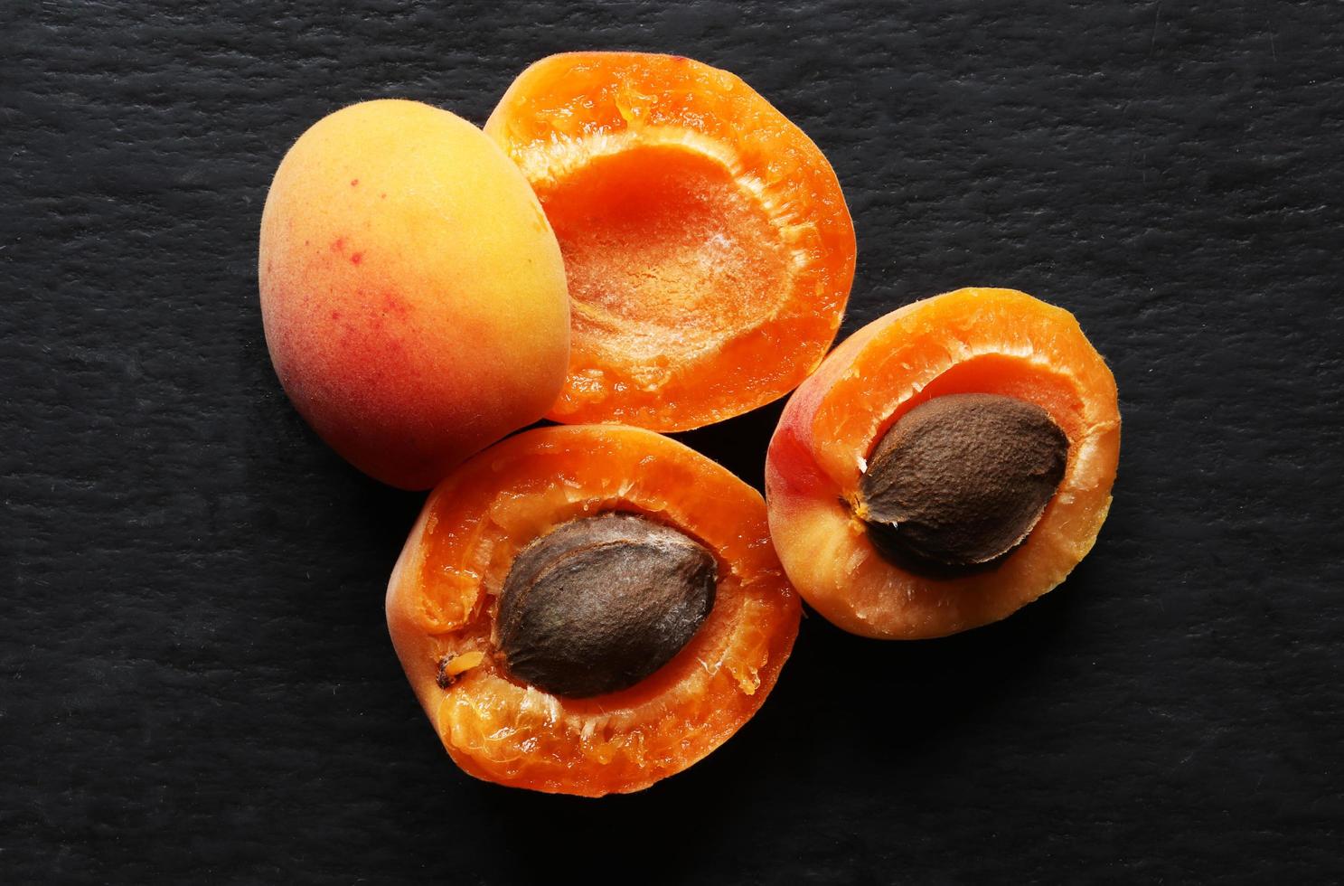 aprikoser halverade på skifferbakgrund foto