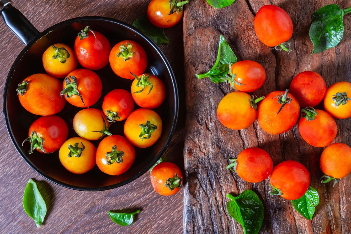 färska tomater i en panna på en träbakgrund foto