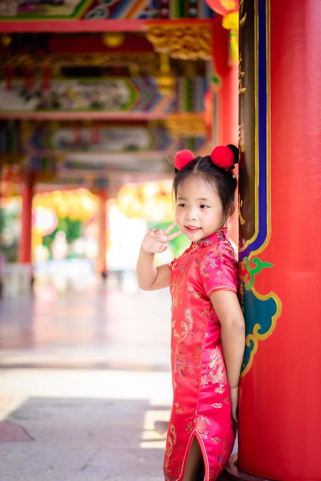 söt liten asiatisk tjej i kinesisk traditionell klänning. foto