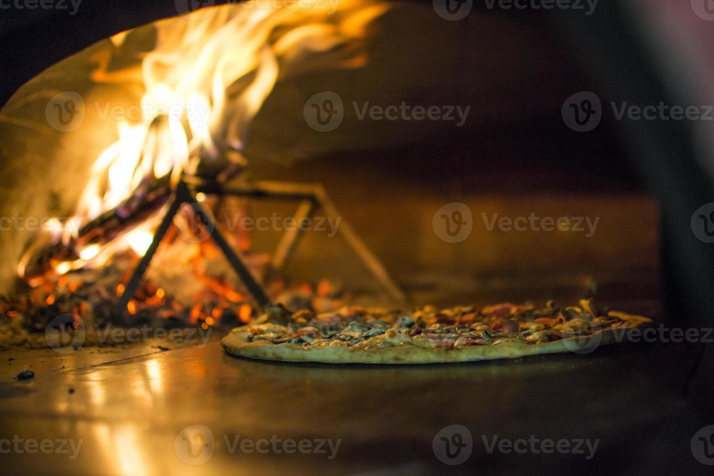 pizza nära de sten spis med brand. bakgrund av en traditionell pizzeria restaurang med en brand plats. foto