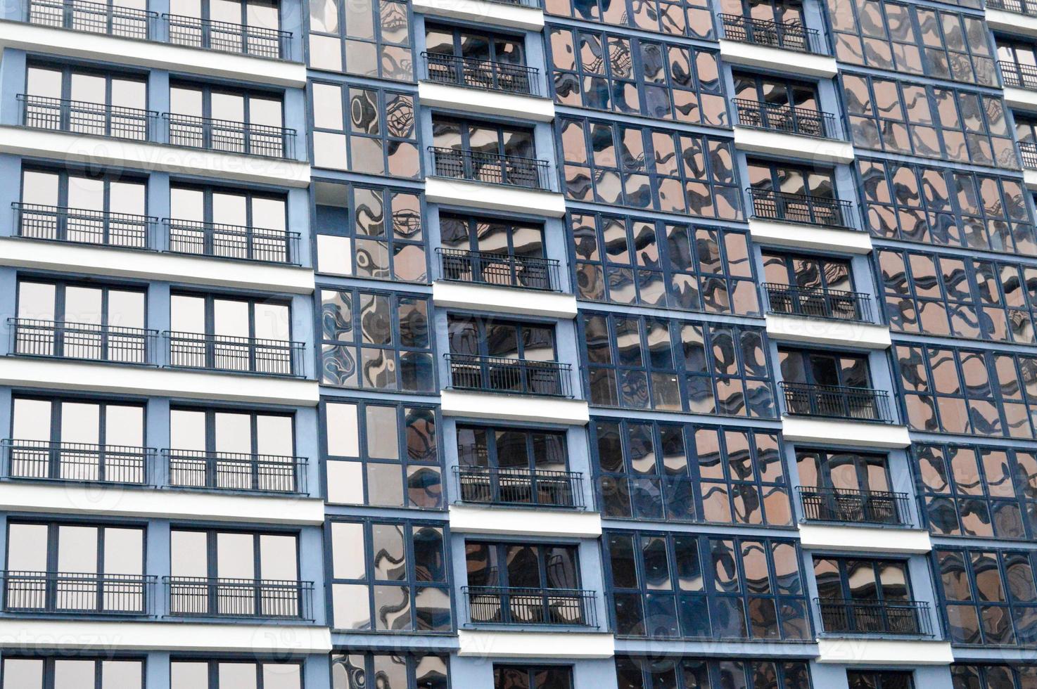 skön modern blå glas glasfiber fönster av de Fasad vägg av en modern skyskrapa byggnad hus. bakgrund, textur foto