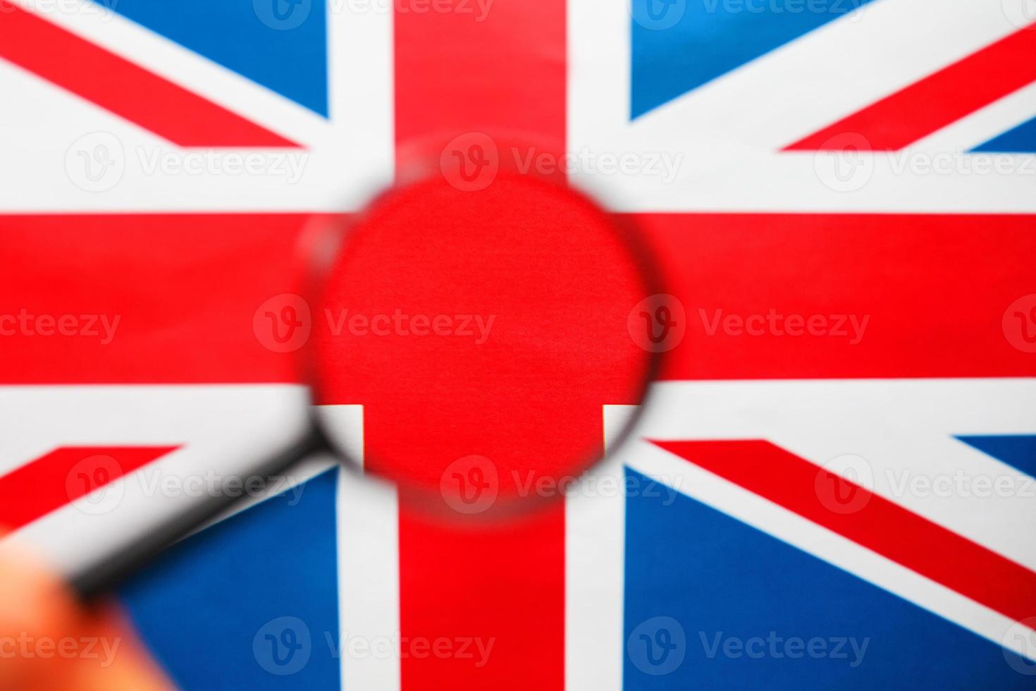 Storbritannien flagga ser genom en förstorande glas. de studie av de historia och kultur av de människor av de bra Land av england. de begrepp av studerar geografi, tull och de språk foto