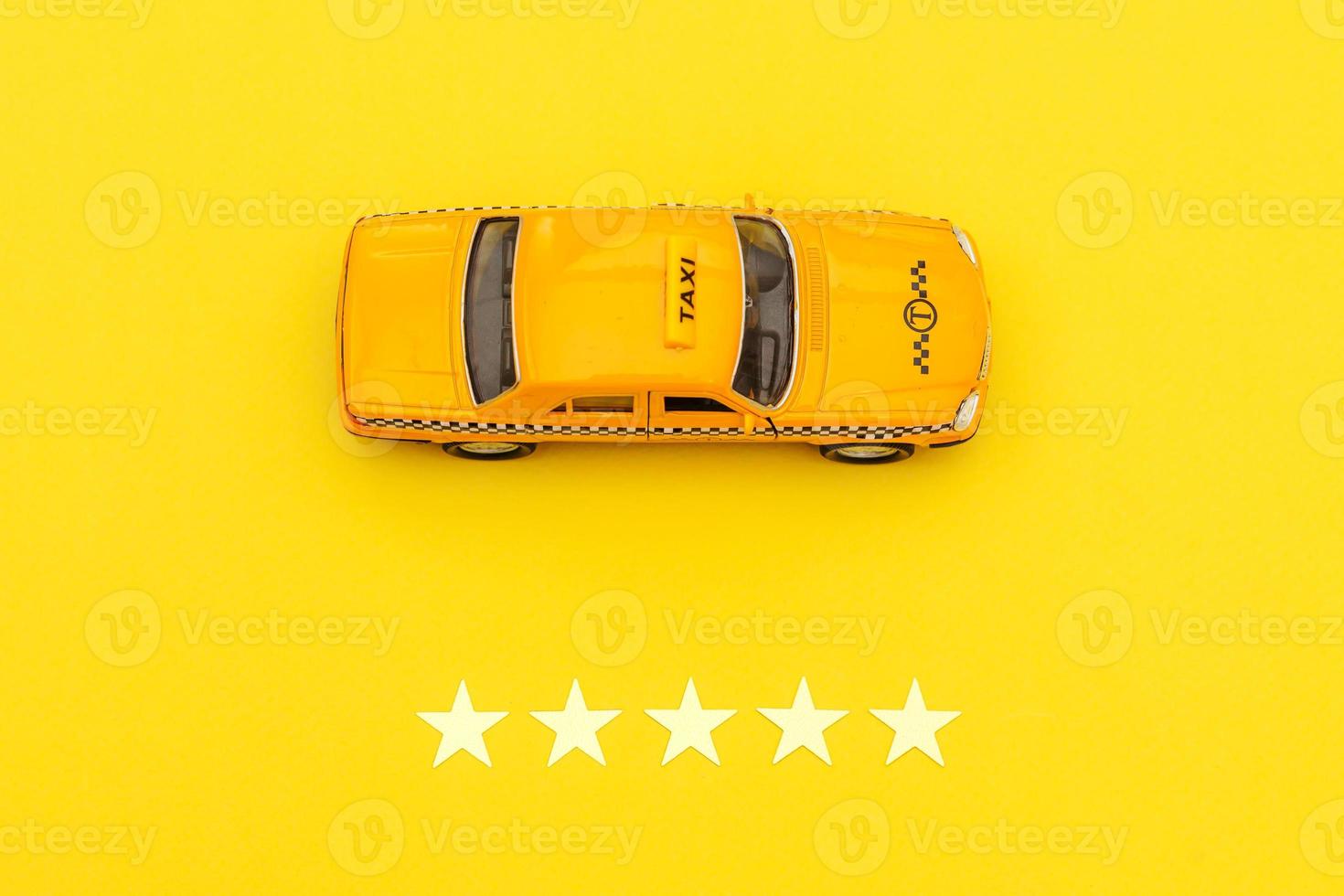 gul leksaksbil taxi cab och 5 stjärnor betyg isolerad på gul bakgrund. smartphoneapplikation av taxitjänst för onlinesökning, ringa och boka taxikoncept. taxi symbol. kopieringsutrymme. foto