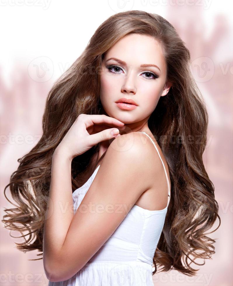 vacker ung kvinna med långt lockigt hår foto
