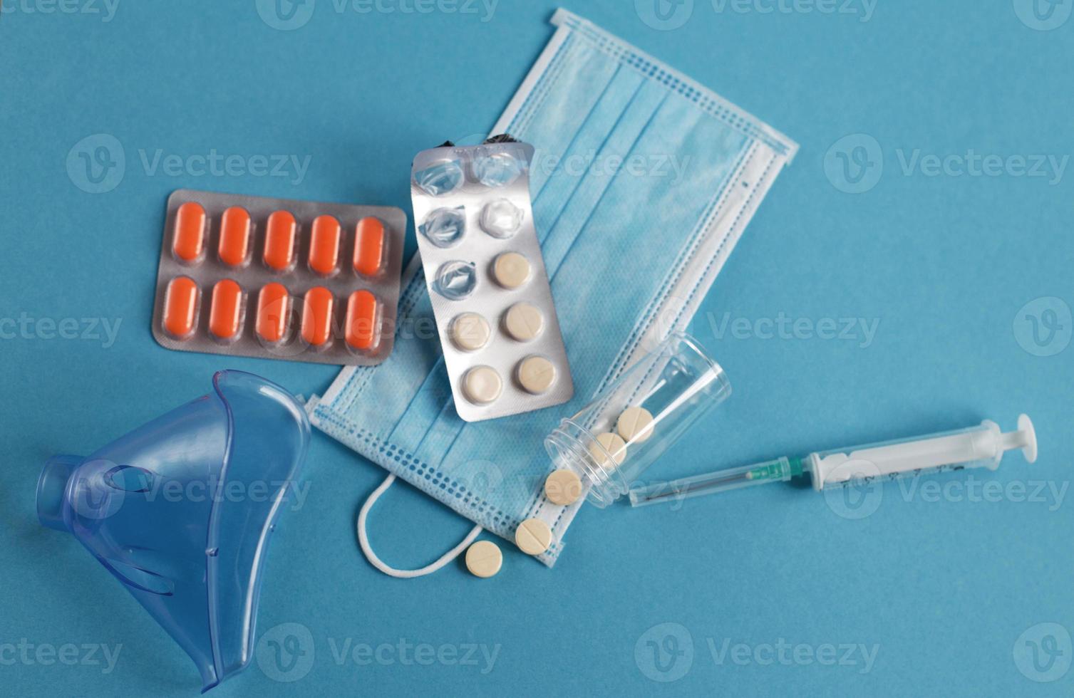 medicinsk mask, spruta, mask för inandning och tabletter stänga på de blå bakgrund. coronavirus, influensa sjukdom begrepp foto