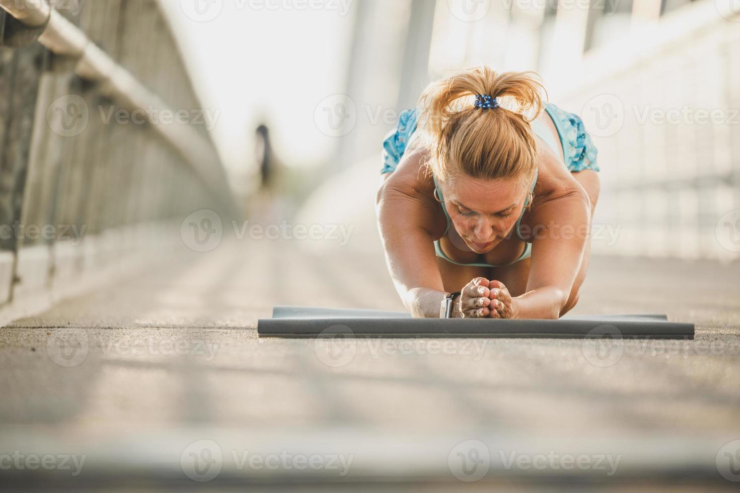 passa kvinna håller på med stretching övningar medan arbetssätt upp utomhus Träning foto