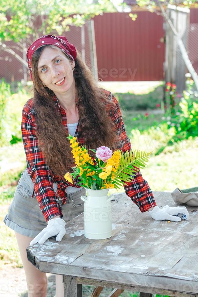 porträtt av en leende jordbrukare flicka med en bukett av blommor på de gata foto