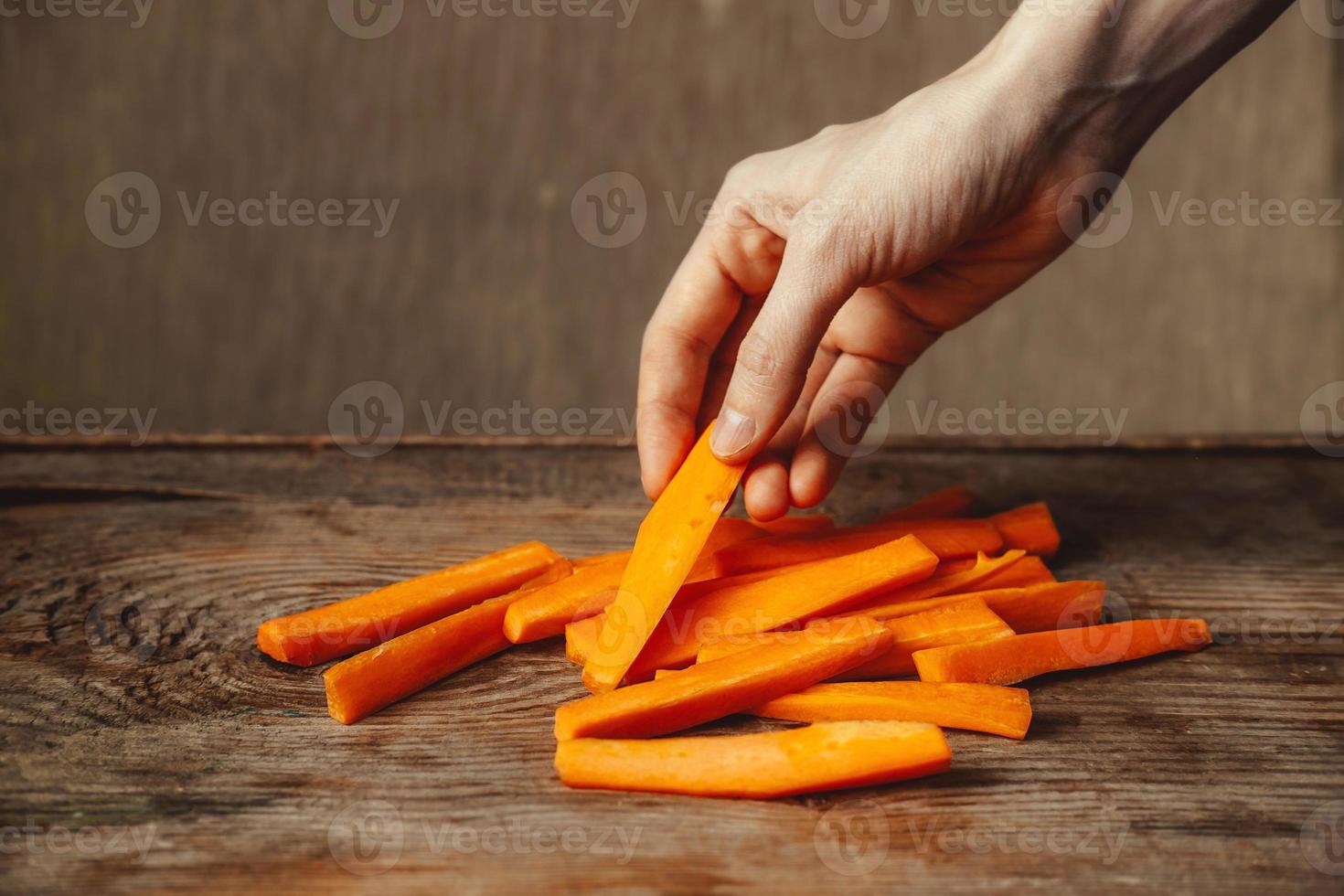 en Bra mellanmål. vegetabiliska snacks. morot snacks. friska mat. vitamin a. bitar av morötter på en trä- bakgrund. foto