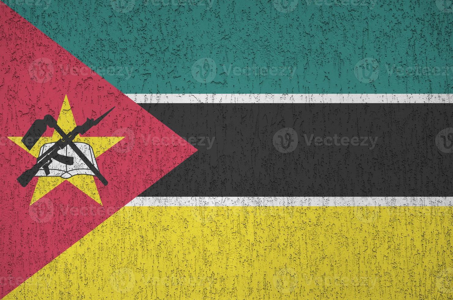 moçambique flagga avbildad i ljus måla färger på gammal lättnad putsning vägg. texturerad baner på grov bakgrund foto