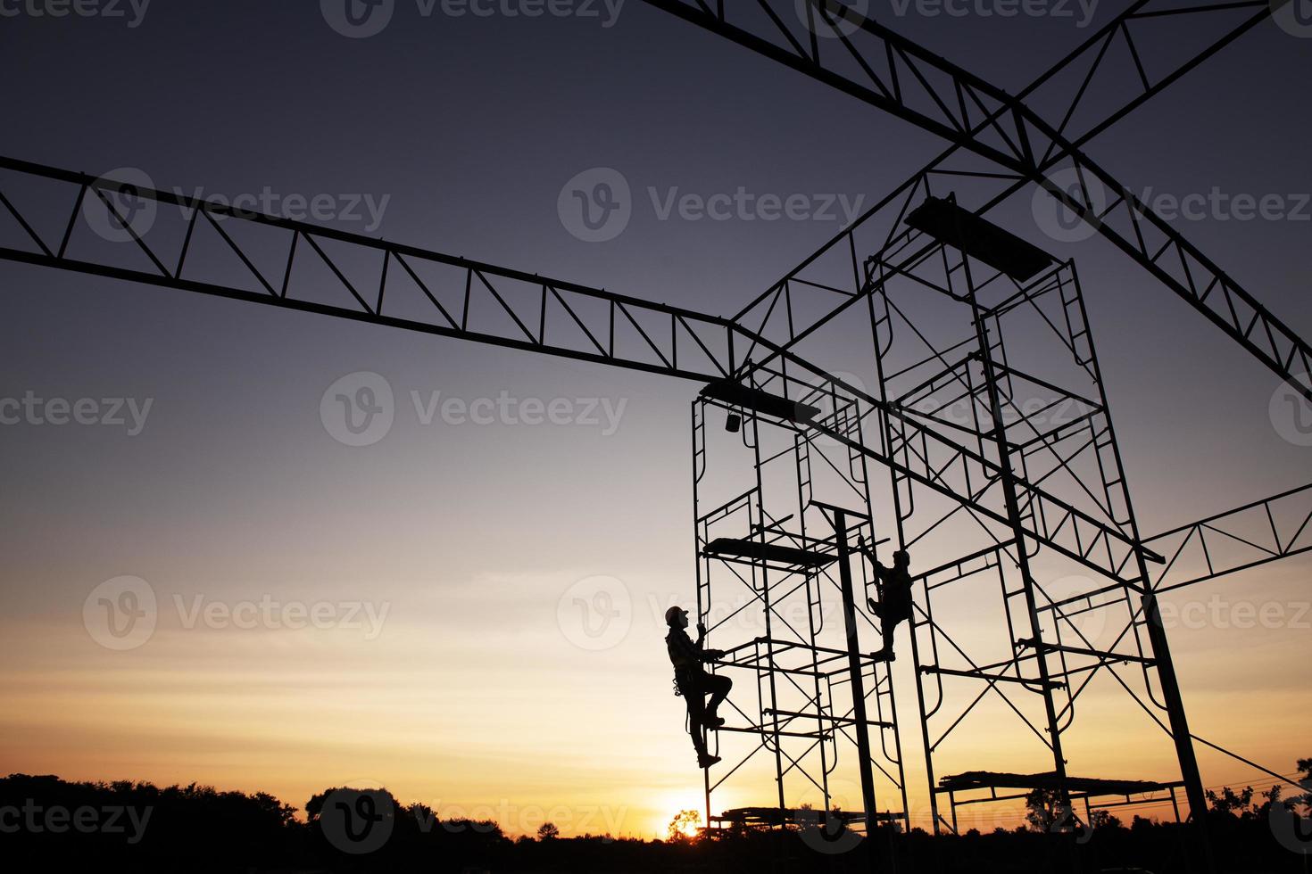 lagarbete konstruktion arbetstagare installation byggnadsställningar i industriell konstruktion solnedgång himmel bakgrund över tid jobb silhuett. foto