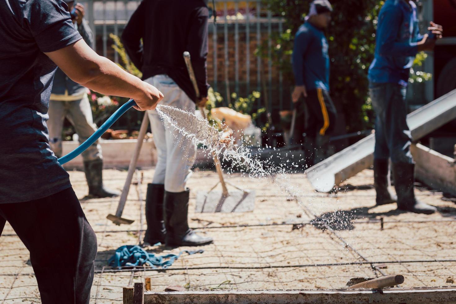 arbetstagare vattning jord framställning de betong i de fundament. foto