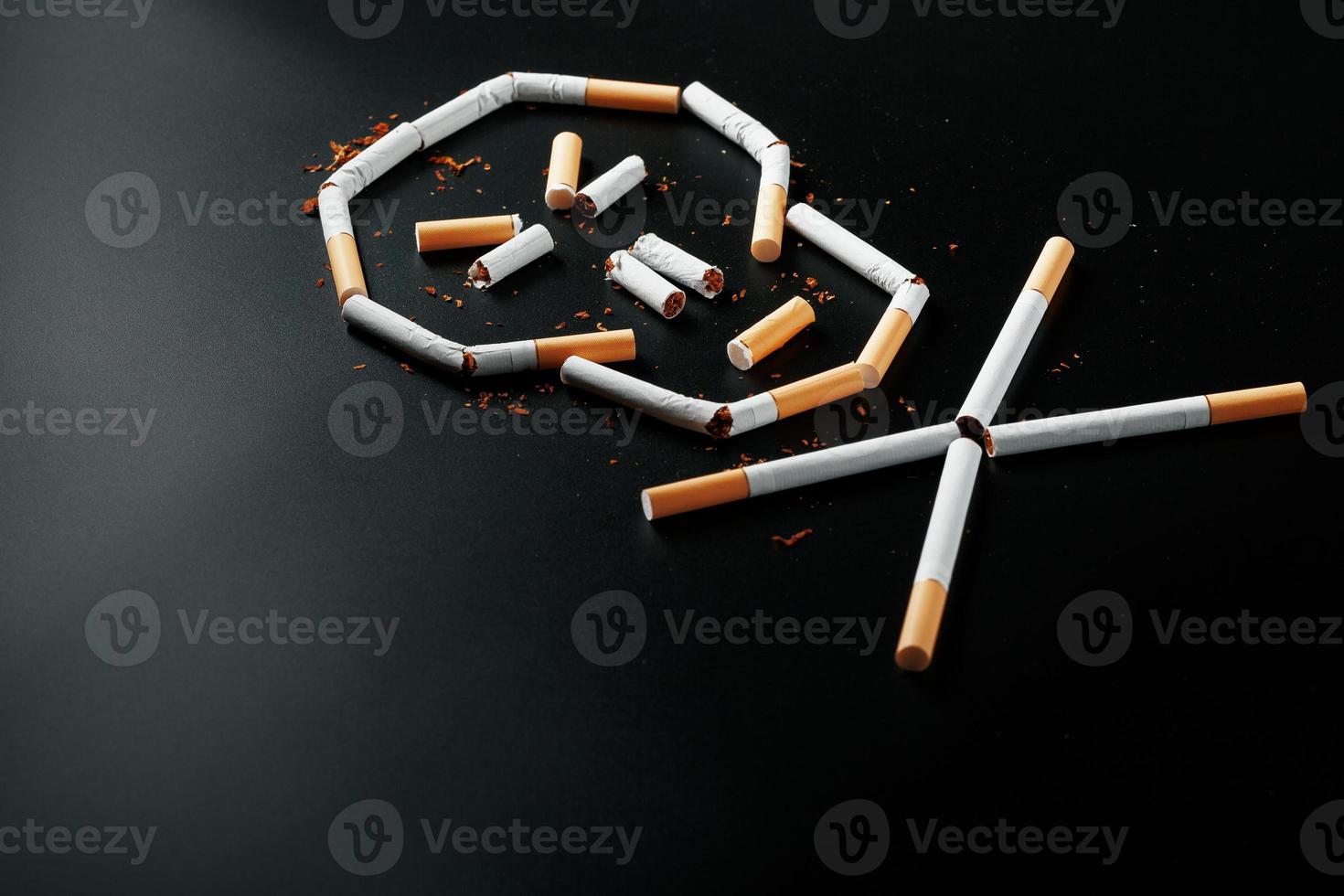 skalle från cigaretter på en svart bakgrund. de begrepp av rökning dödar. mot de begrepp av rökning som en dödligt vana, nikotin gifter, cancer från rökning, sjukdom, sluta rökning. foto