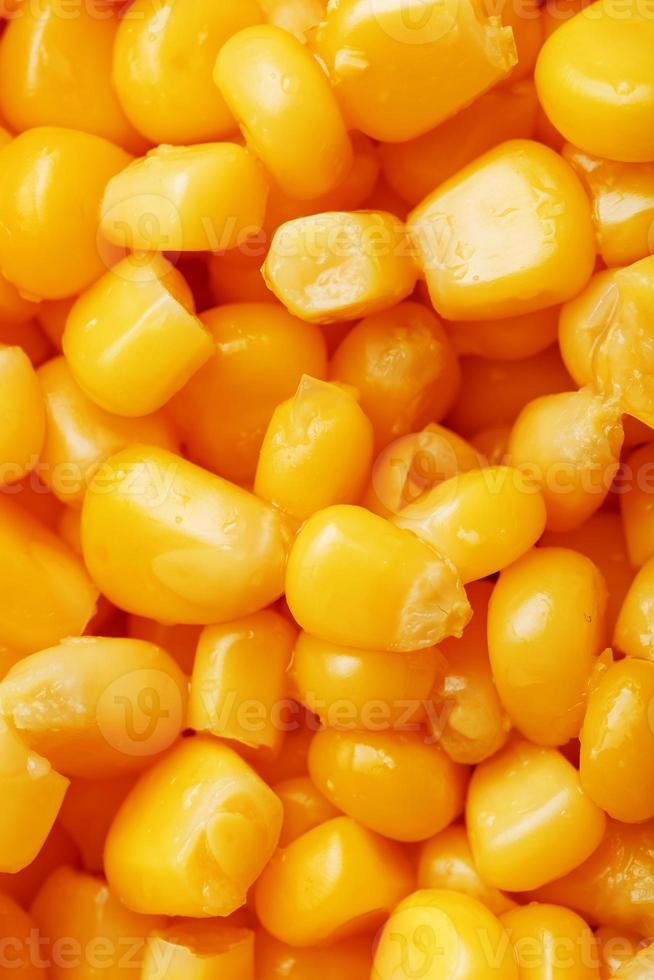 gyllene konserverad majs, som distribuerad på en plan bakgrund och textur av popcorn. innan tittar på en film topp se. närbild foto
