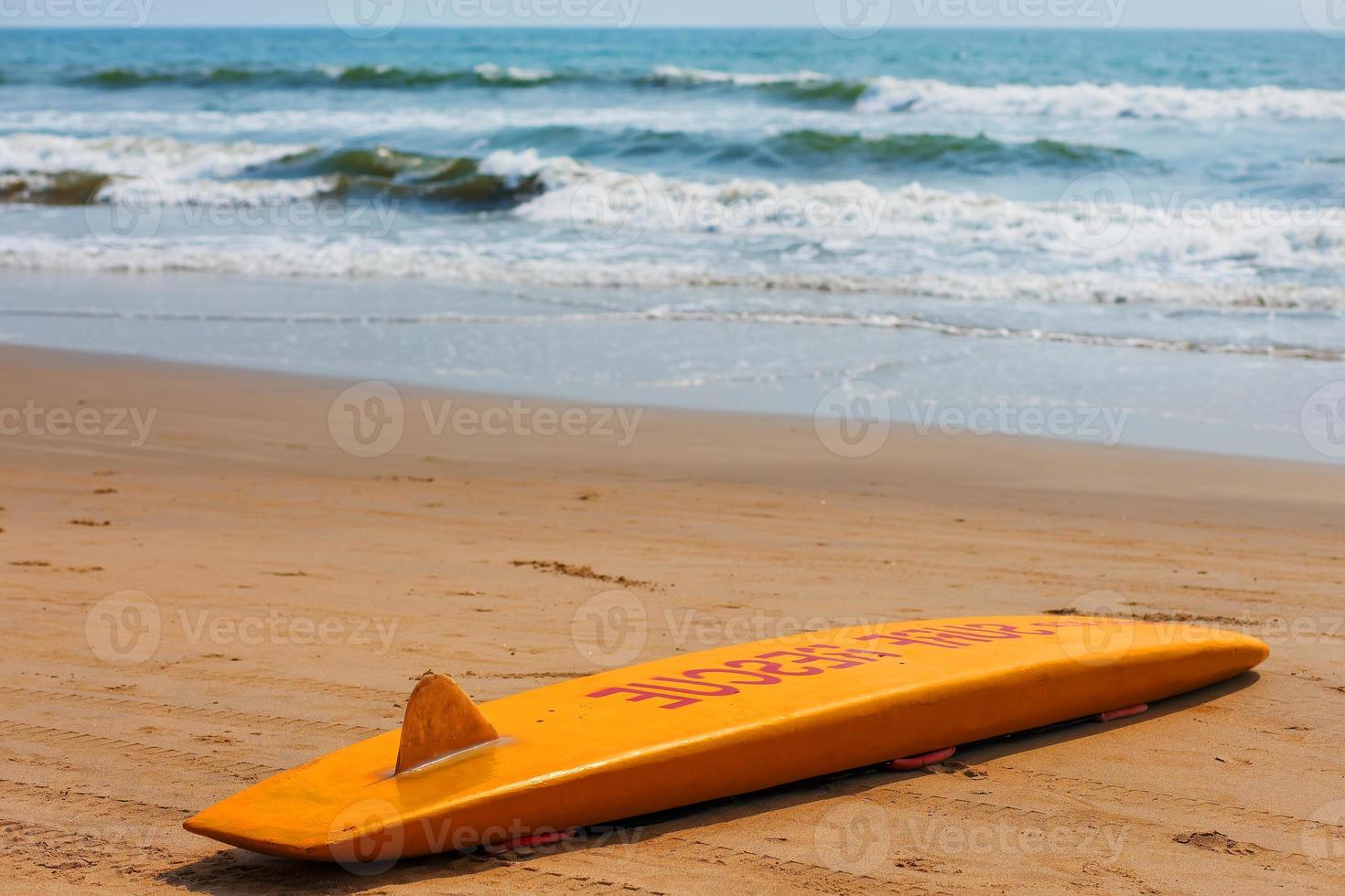 de gul styrelse av de räddare för surfing lögner på de sand Begagnade förbi de livräddare arbetssätt på de arambol strand foto