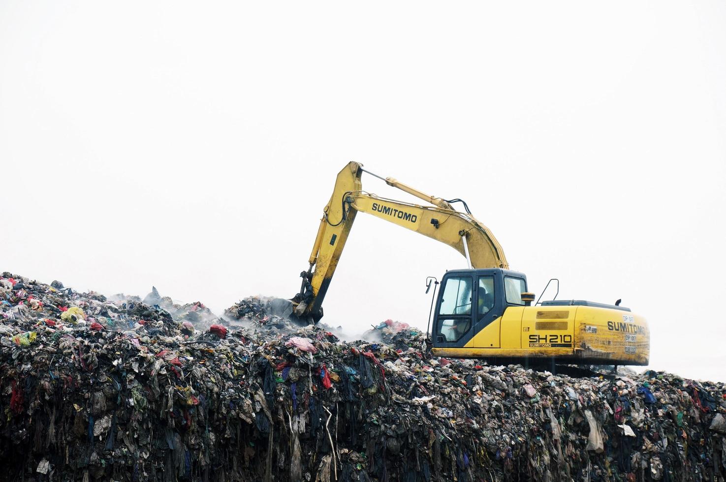 sangatta, öst kalimantan, Indonesien, 2020 - traktor arbetssätt på sopor dumpa i deponi. människor arbetssätt på deponi webbplats. foto