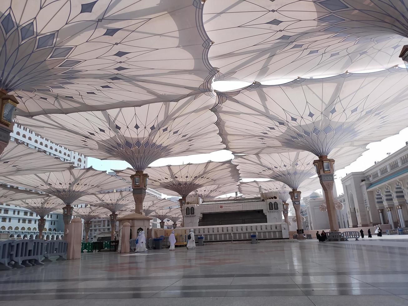 medina, saudi Arabien, 2022 - paraply konstruktion på de fyrkant av al-masjid an-nabawi eller profet muhammed moské är skyddande människor från Sol på dagtid och arbete som lampor på natt foto