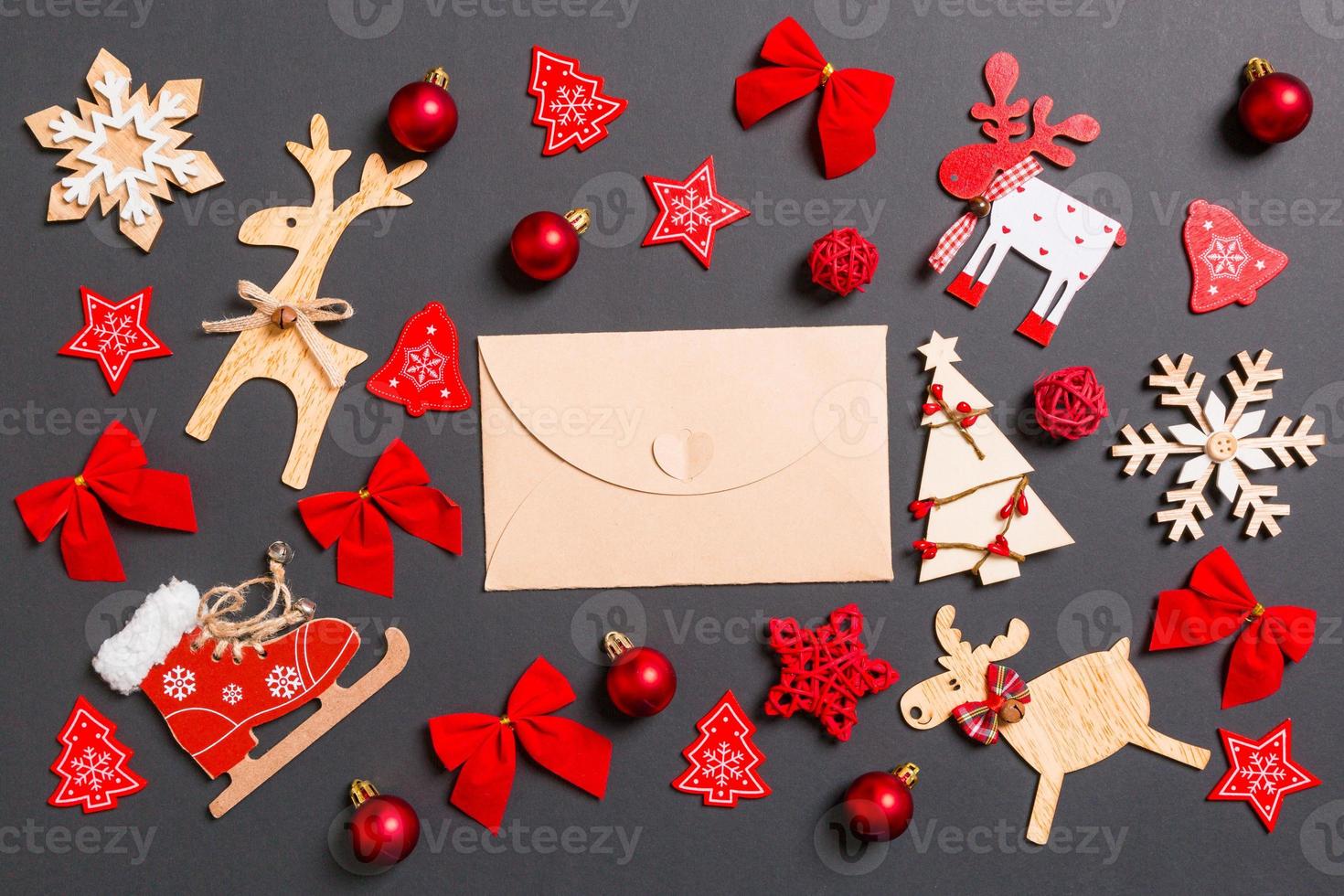 jul svart bakgrund med Semester leksaker och dekorationer. topp se av hantverk kuvert. Lycklig ny år begrepp foto