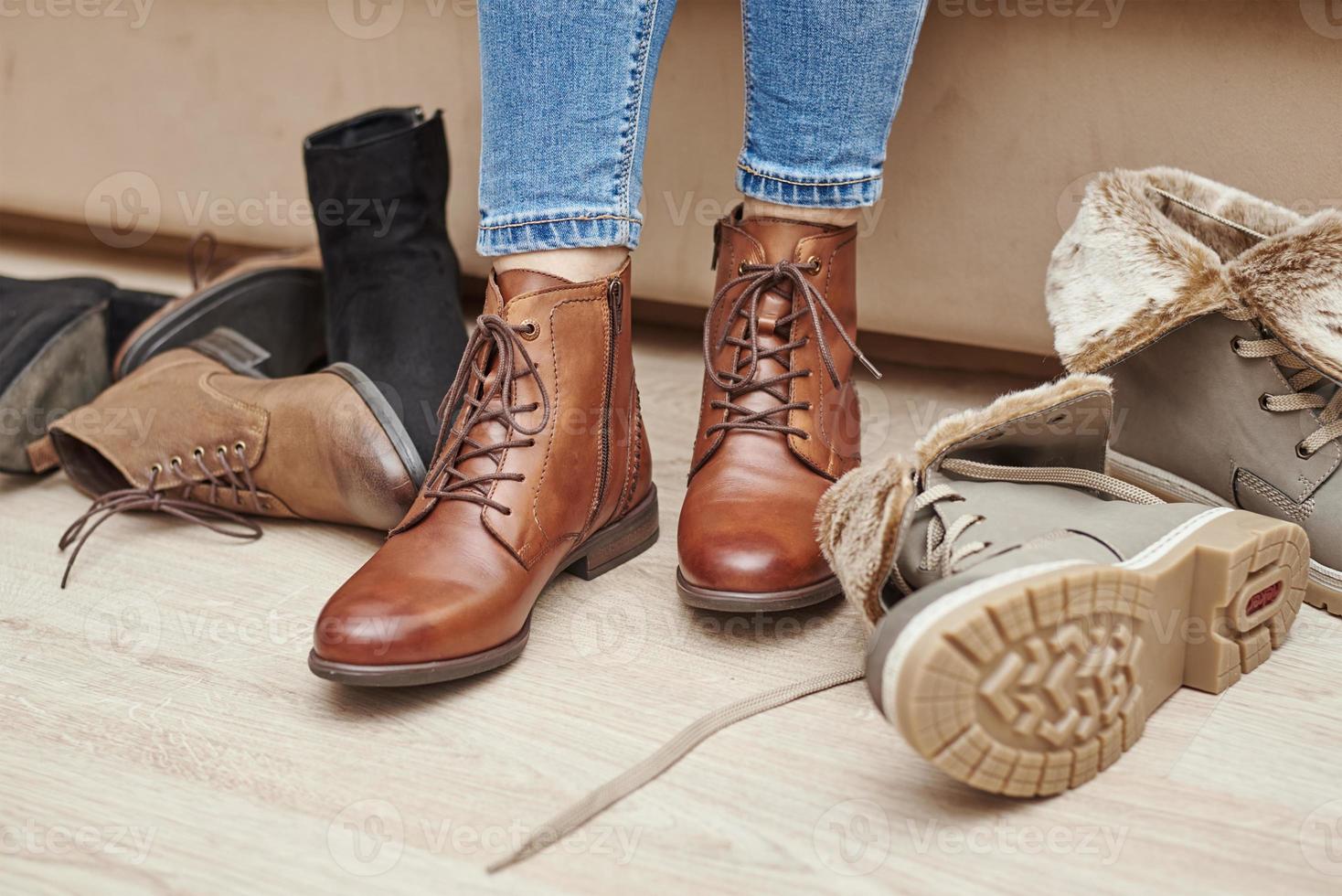 kvinna väljer bekväm brun läder skor bland knippa av de annorlunda par foto