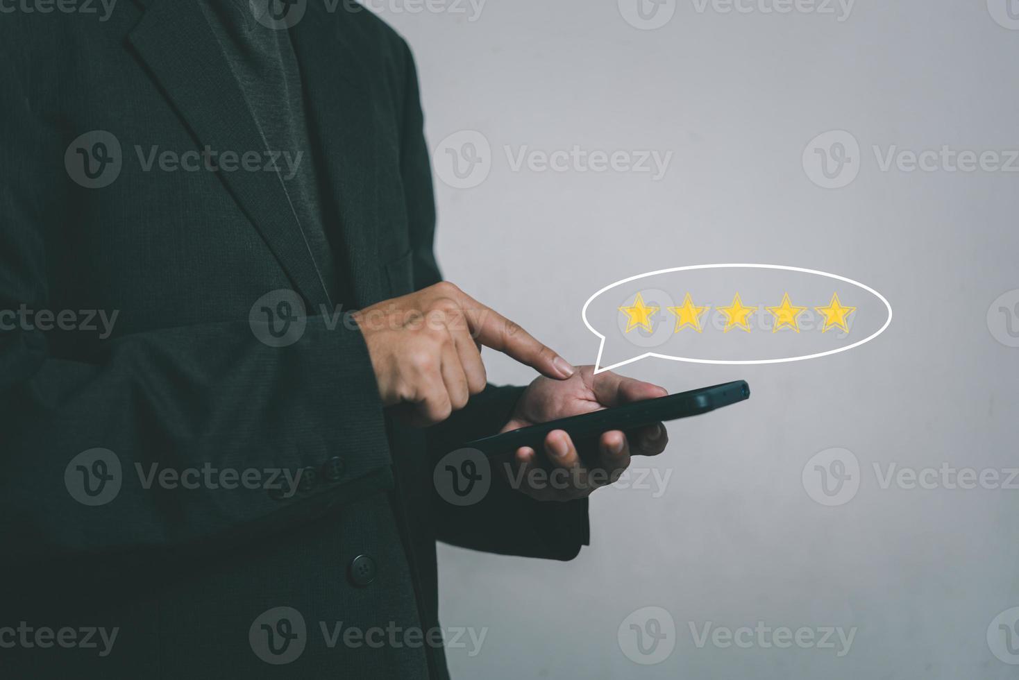 affärsman hand använder sig av smart telefon och ge fem stjärna symbol ikon för respons recension tillfredsställelse service betyg av produkt. tillfredsställelse begrepp. foto