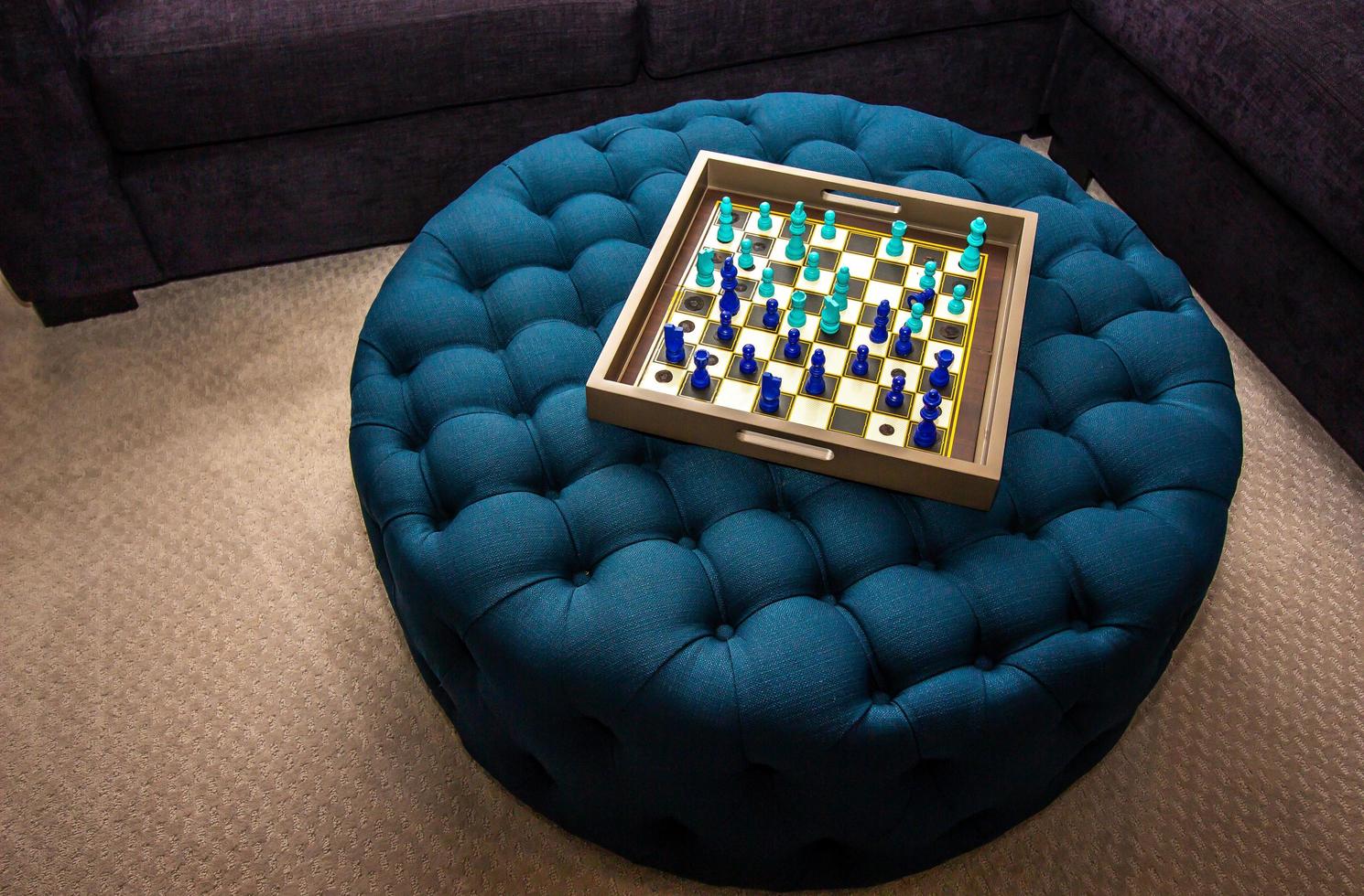 trä- bricka schack styrelse på blå ottoman foto