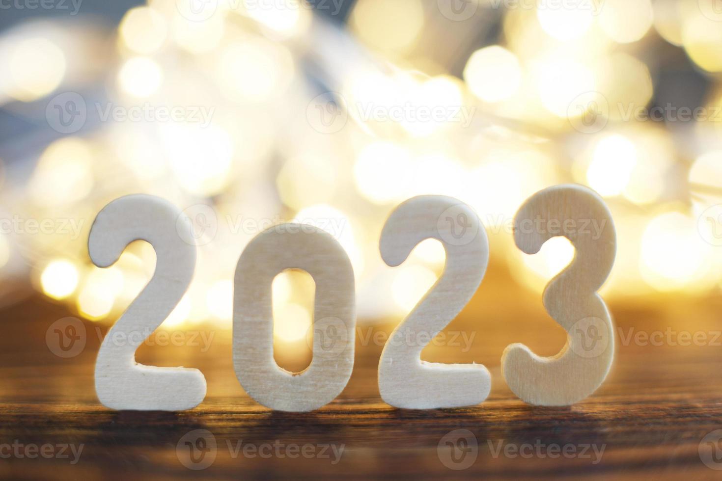 trä- siffra 2023 på jul vacker skinande guld bakgrund. gnistra festlig suddig bokeh foto