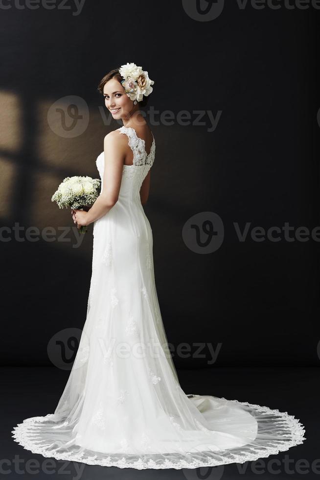 glamorös ung brud i bröllopsklänning, leende foto